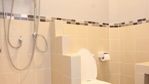 Une salle de bain comprenant des toilettes, une douche et un lavabo.