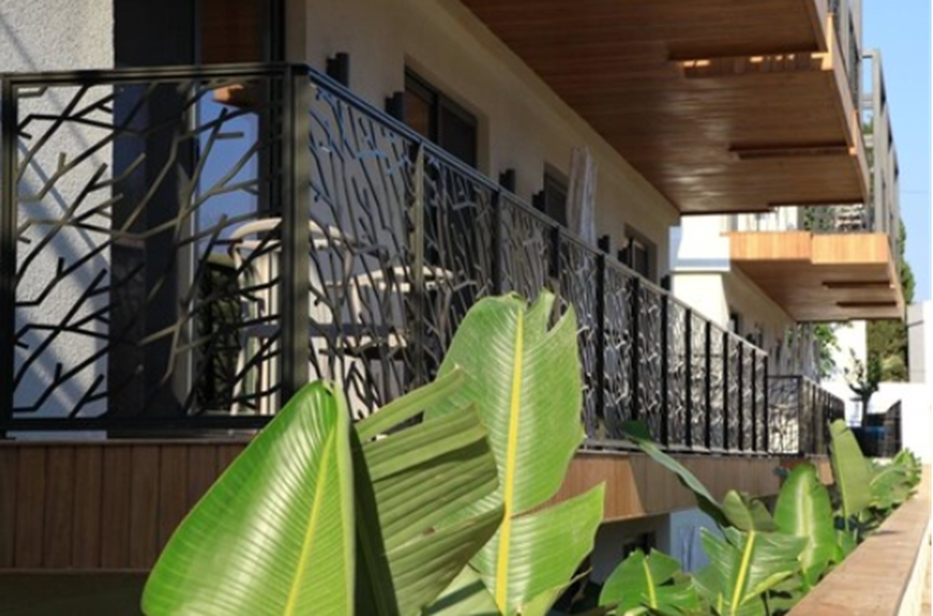 A modern building with a balcony featuring a geometric metal railing.