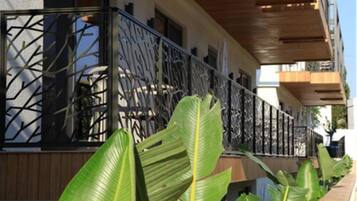 A modern building with a balcony featuring a geometric metal railing.