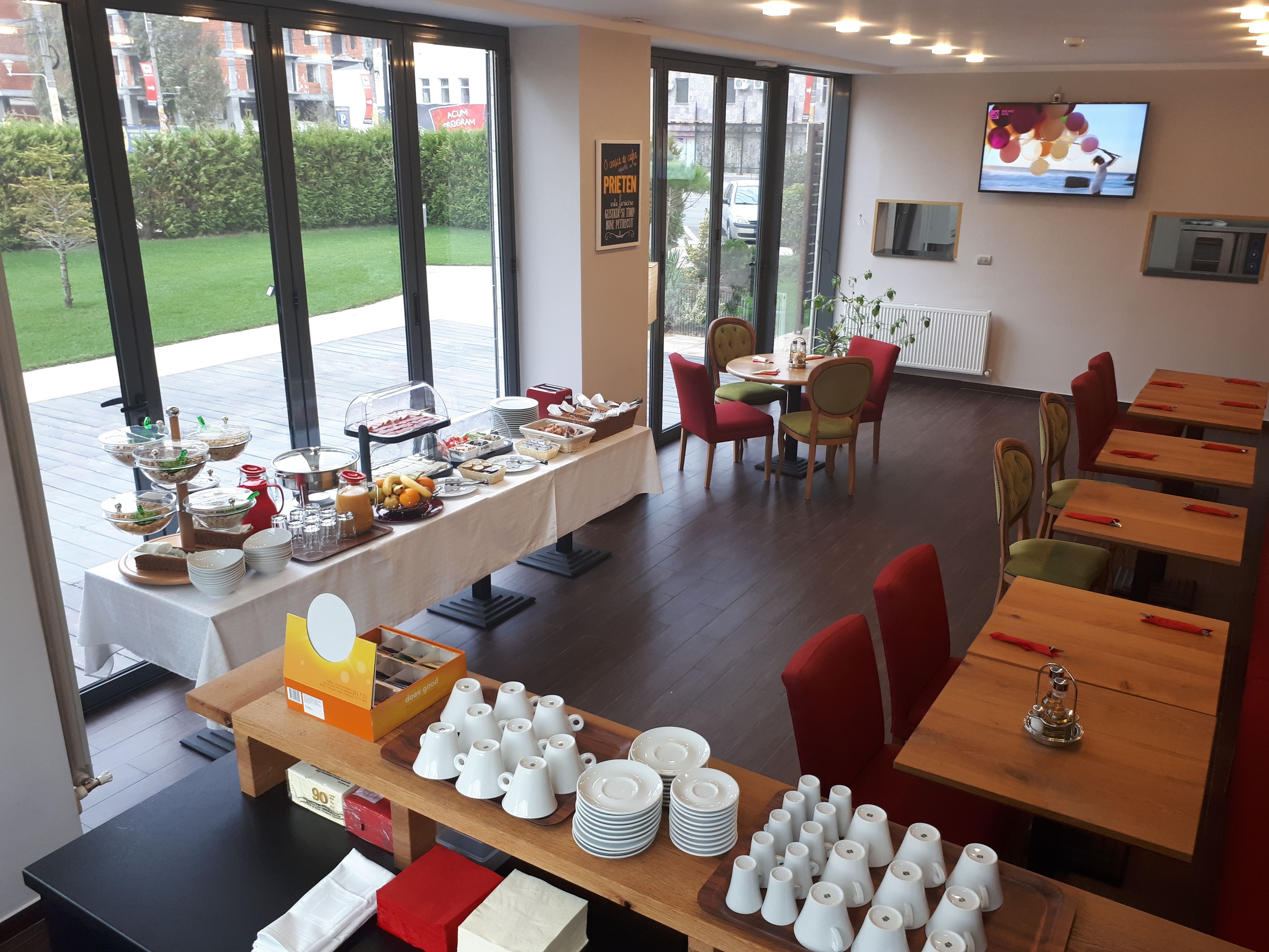 A dining area with a buffet table, chairs, and a television on the wall.