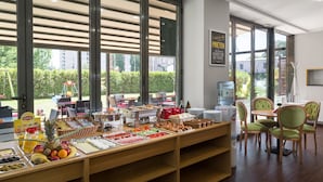 A breakfast buffet with various food items and a water dispenser. - Tomis Garden Apartments (Constanta)