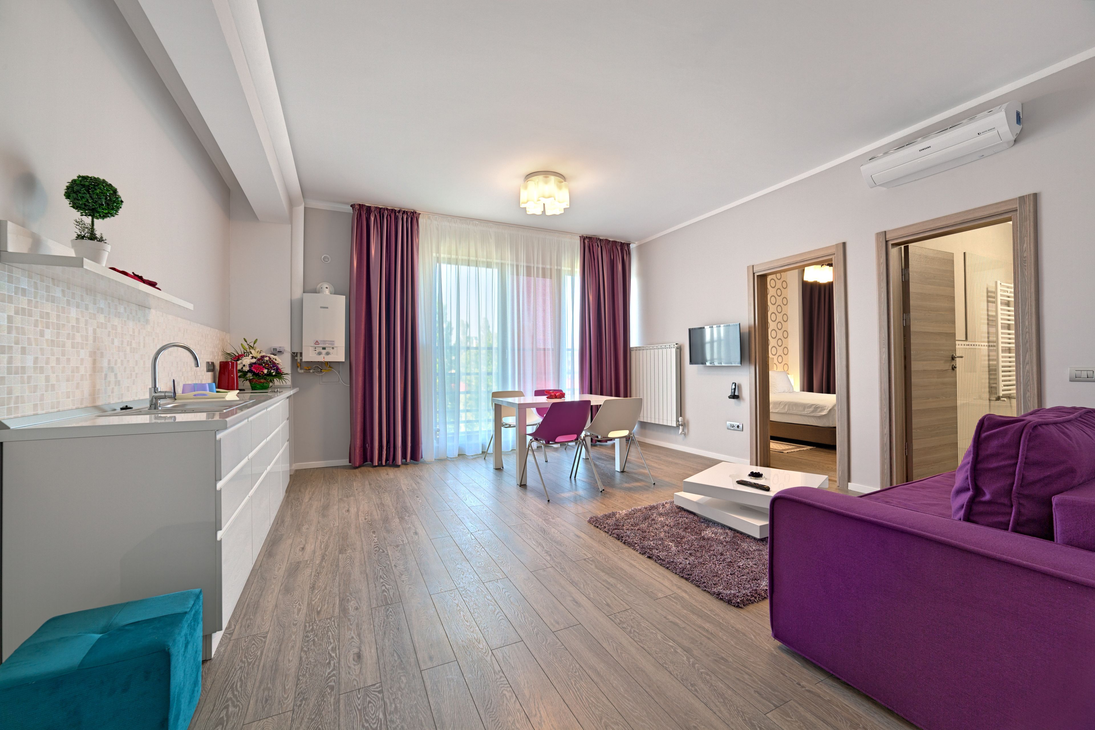 Een modern appartement met keuken, eethoek en zithoek.