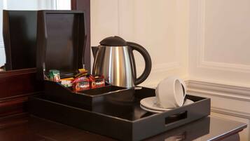 Angolo caffè con bollitore, tazze e snack.