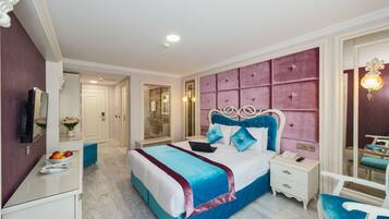 A bedroom with a bed, bedside tables, a mirror, a vanity, and a chair.