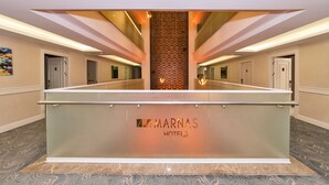 A reception area with a glass barrier, a central decorative wall, and doors leading to other rooms. - Marnas Hotels (Istanbul)