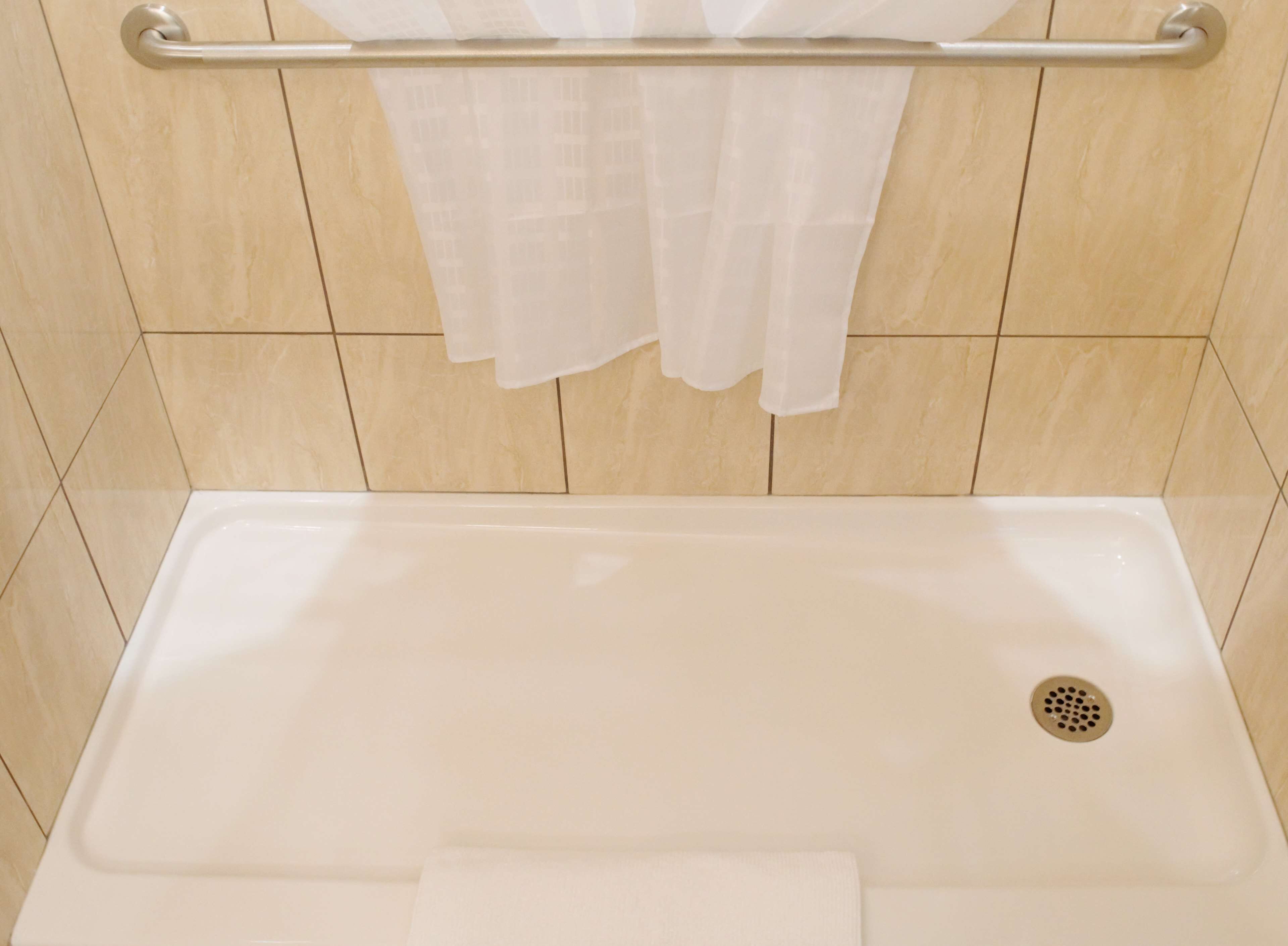 Een badkamer met een bad, een handdoekhouder en een douchegordijn.