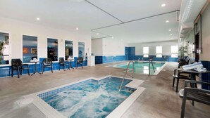 An indoor swimming pool area with multiple seating arrangements and a separate hot tub. - Best Western Plus Moosomin Hotel (Moosomin)