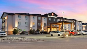 A hotel with multiple floors, a covered entrance, and several cars parked in front. - Best Western Plus Moosomin Hotel (Moosomin)