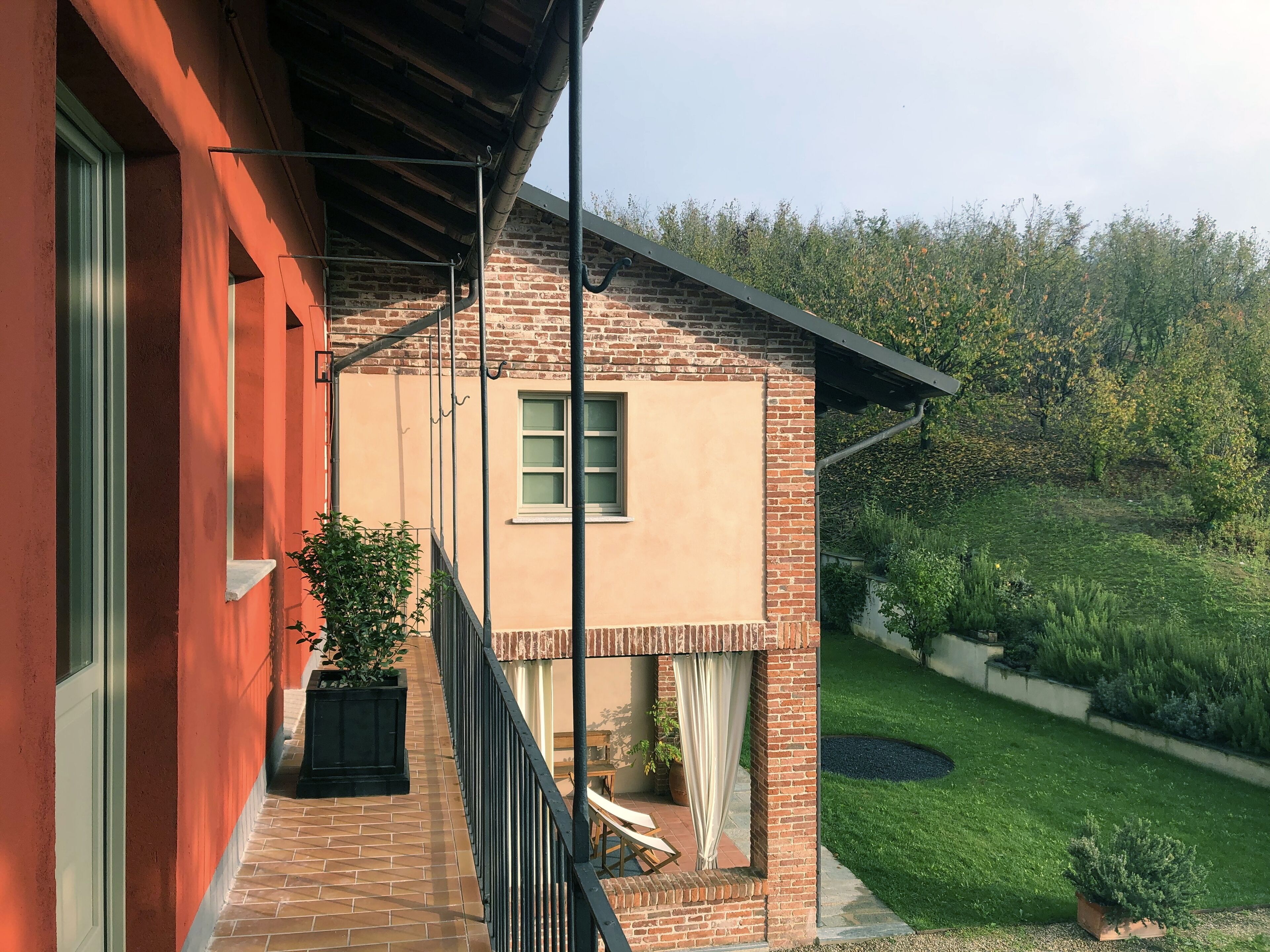 A brick building with a balcony, a window, and a door.