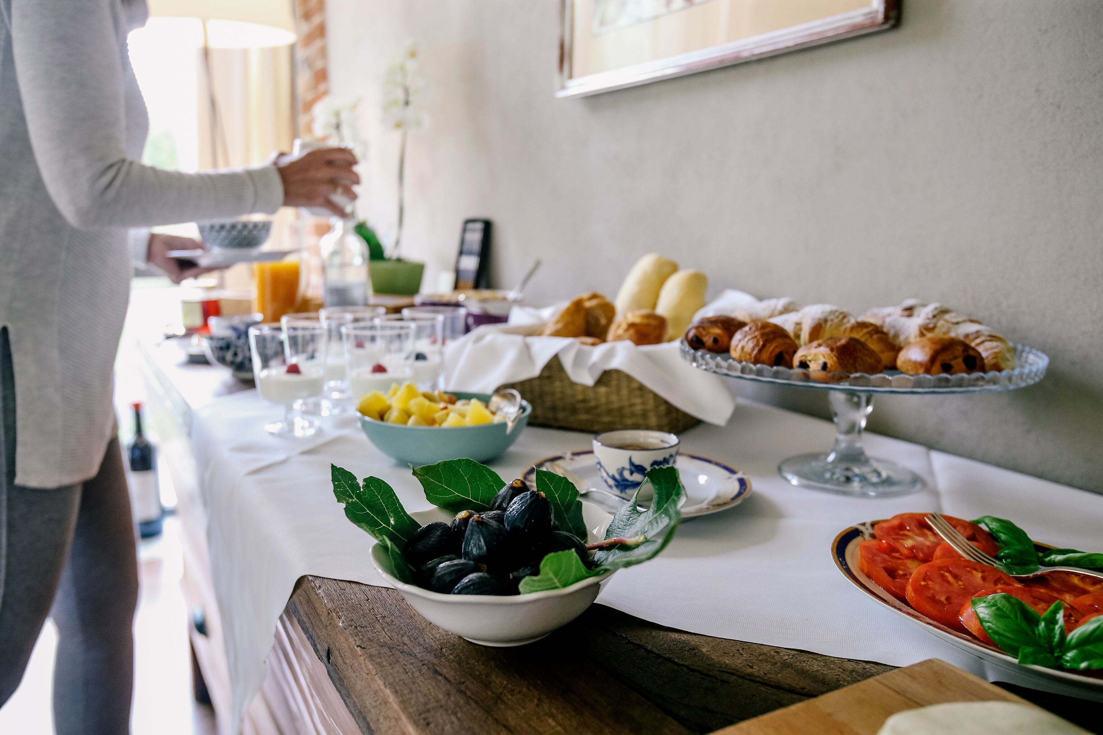 Un buffet de petit-déjeuner proposant une variété d’aliments, avec une personne chargée de servir.