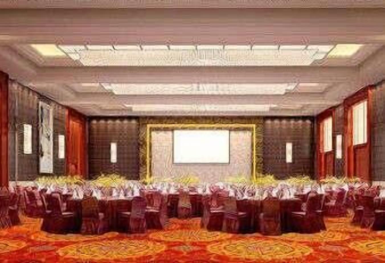 Un salón de conferencias con filas de sillas, una pantalla grande y una alfombra estampada.