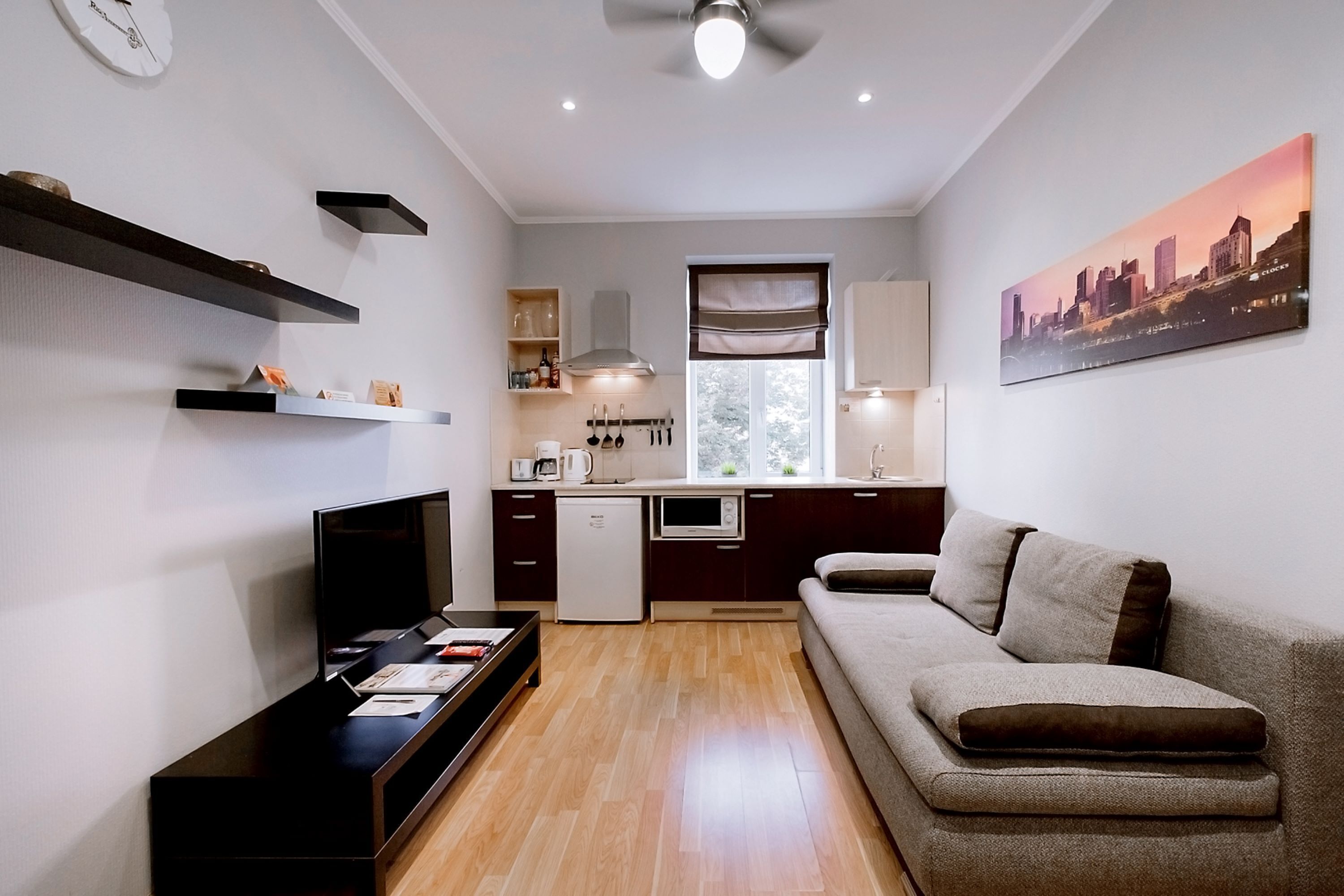 Una sala de estar moderna con una televisión de pantalla plana, un sofá y una mesa de centro.