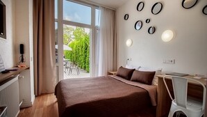 A modern bedroom with a large bed, a desk, and a chair. There are multiple mirrors on the wall and a window with curtains. - RigaApartment SoNaDA Self Check-in Aparthotel, Center, Private Parking (Riga)
