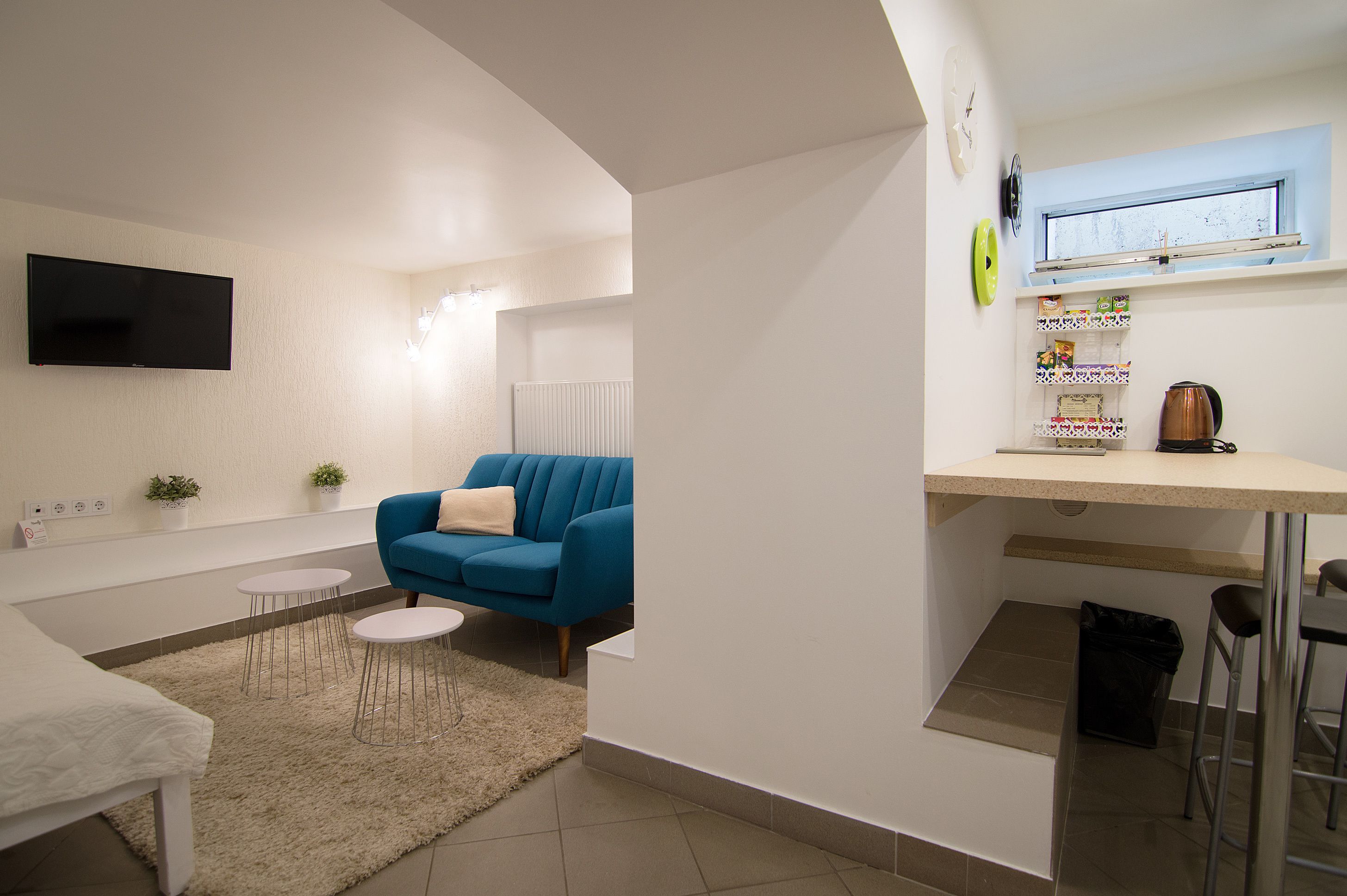 A modern kitchen with a built-in oven, a coffee machine, and a window above the counter.
