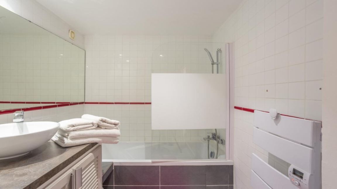 Une salle de bain moderne avec un grand lavabo, une douche à parois de verre et une baignoire.