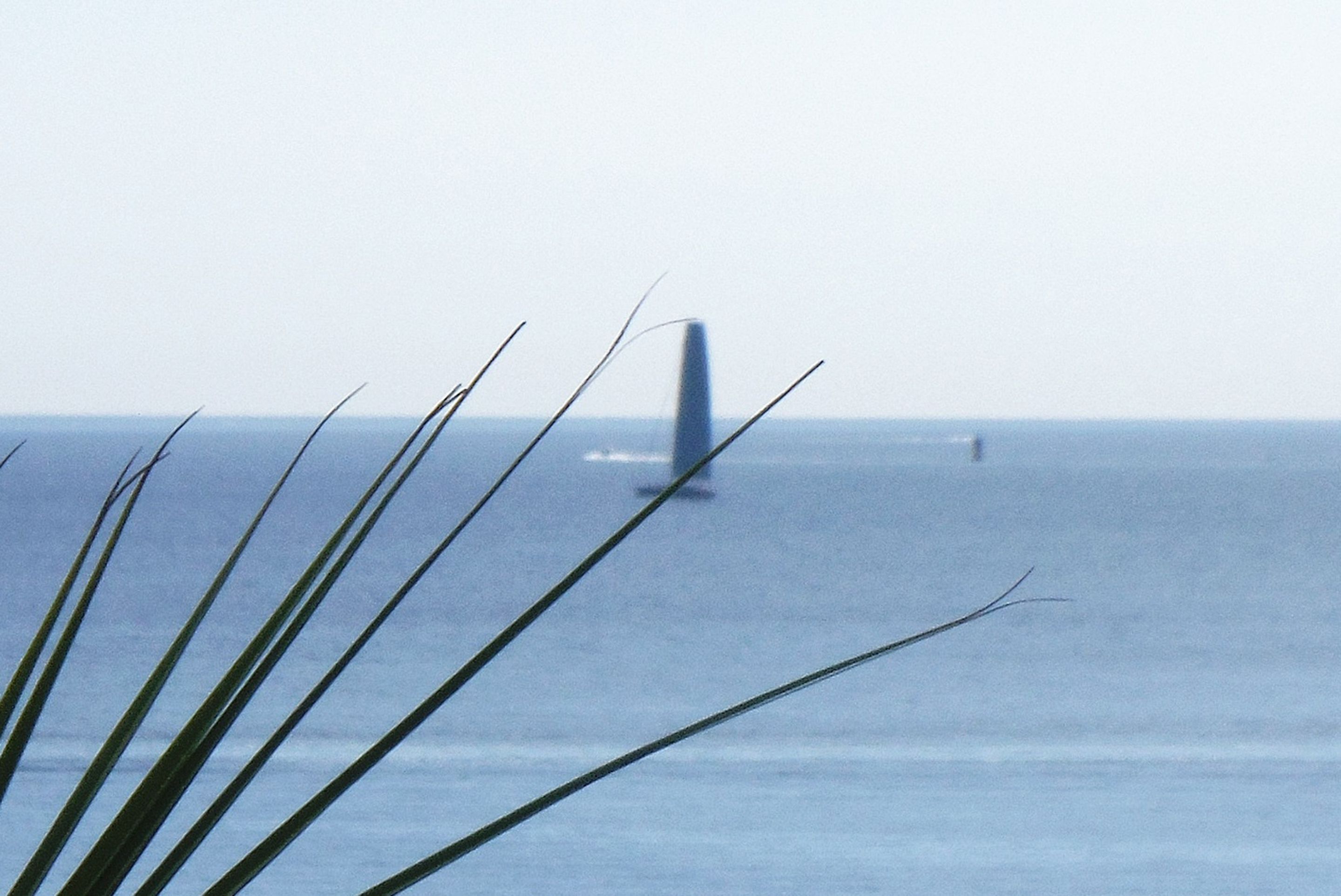 A view of the ocean with a bridge in the distance.