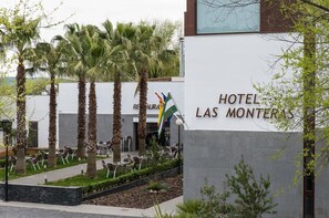A hotel entrance with a sign reading "HOTEL LAS MONTERAS" and a restaurant named "RESTAURANT LAS MONTERAS" in the background.