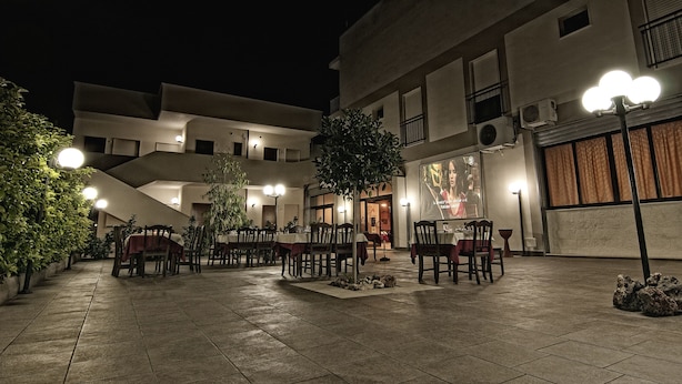 Un espace de restauration en plein air, avec des tables et des chaises, entouré d’immeubles dotés de balcons et de climatiseurs.