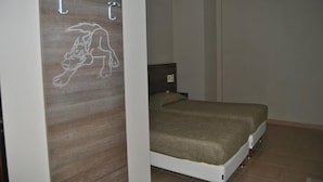 Une chambre à coucher avec un lit, un panneau en bois orné d’une illustration de chien et un climatiseur fixé au mur.