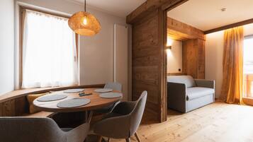 Un intérieur moderne avec une table à manger en bois, des chaises grises et un luminaire suspendu.