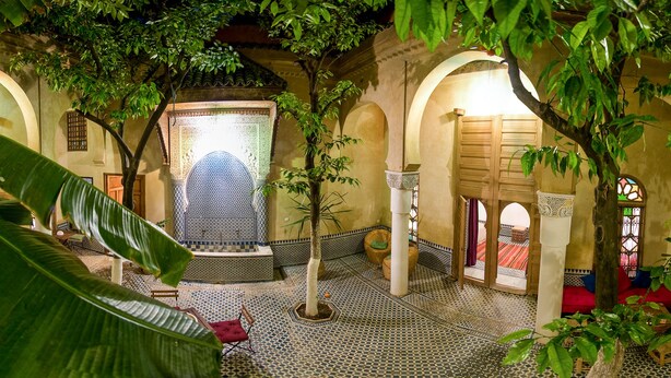 An interior courtyard with a fountain, arches, and tiled flooring. - Riad La maison d'à côté (Meknes)