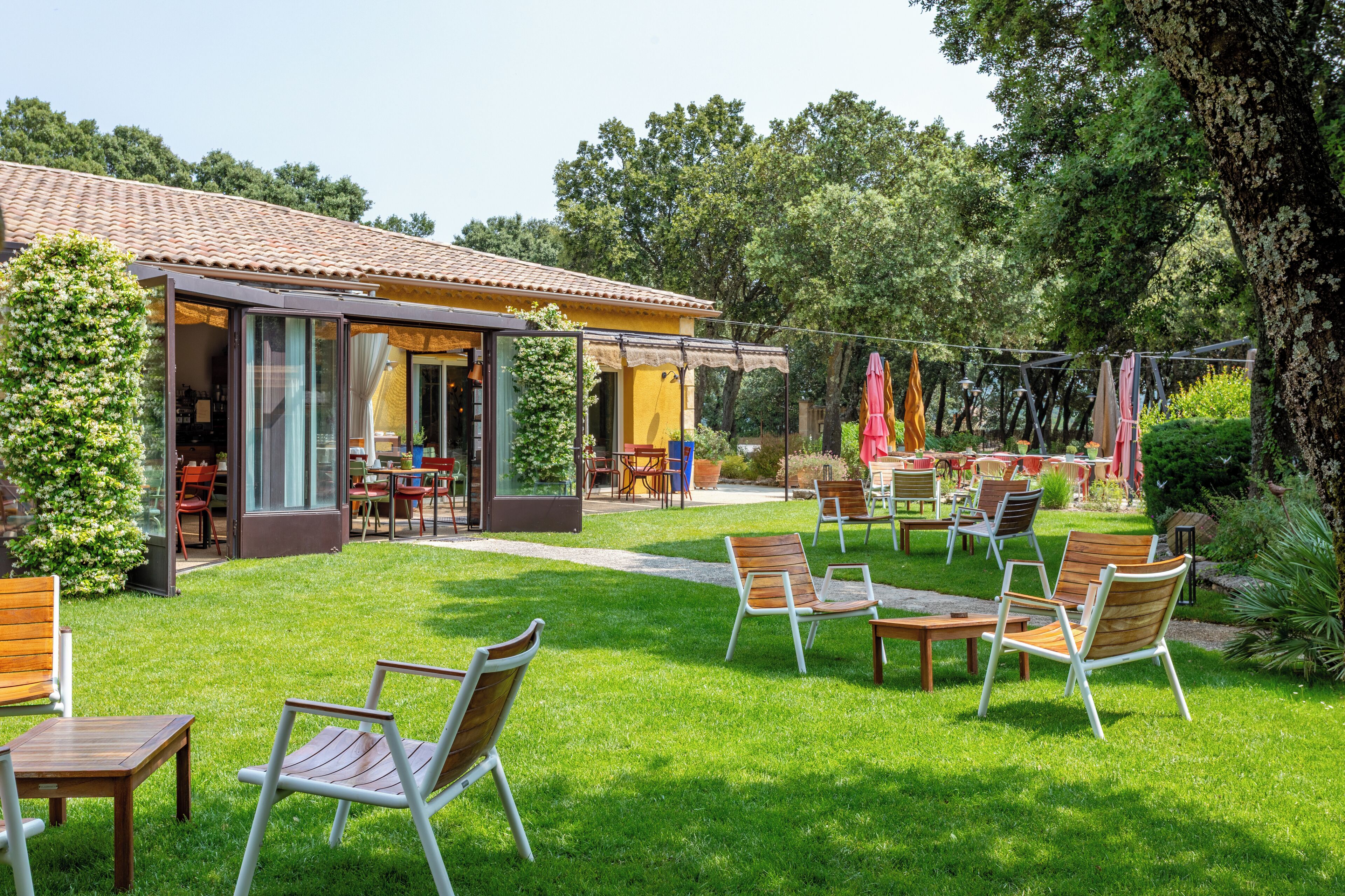 A patio area with outdoor seating and a building with a tiled roof.