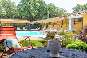 Una piscina al aire libre, camas de piscina gratis, sombrillas