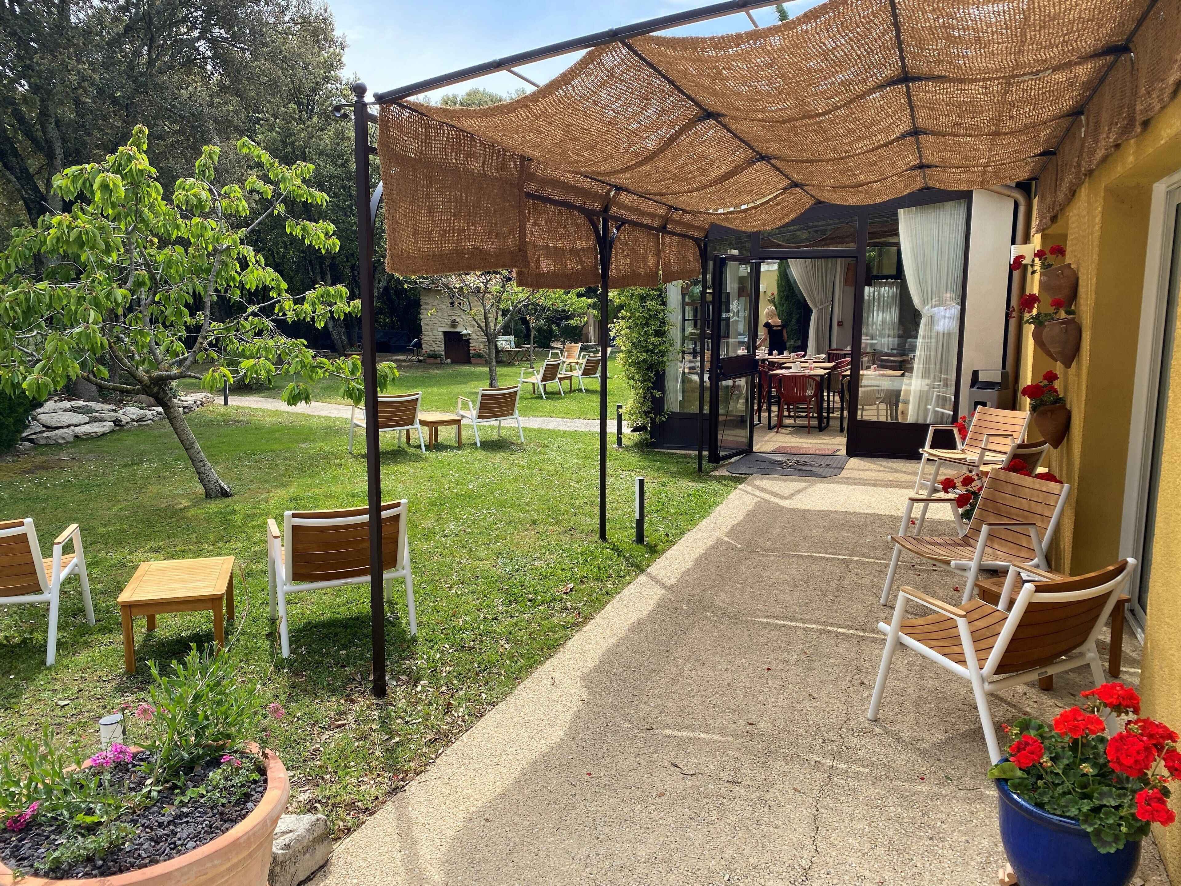 Eine Terrassengruppe mit Sitzgelegenheiten, einem Gartenhaus und Blick auf den Garten.