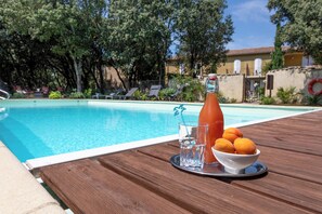 Una piscina al aire libre, camas de piscina gratis, sombrillas