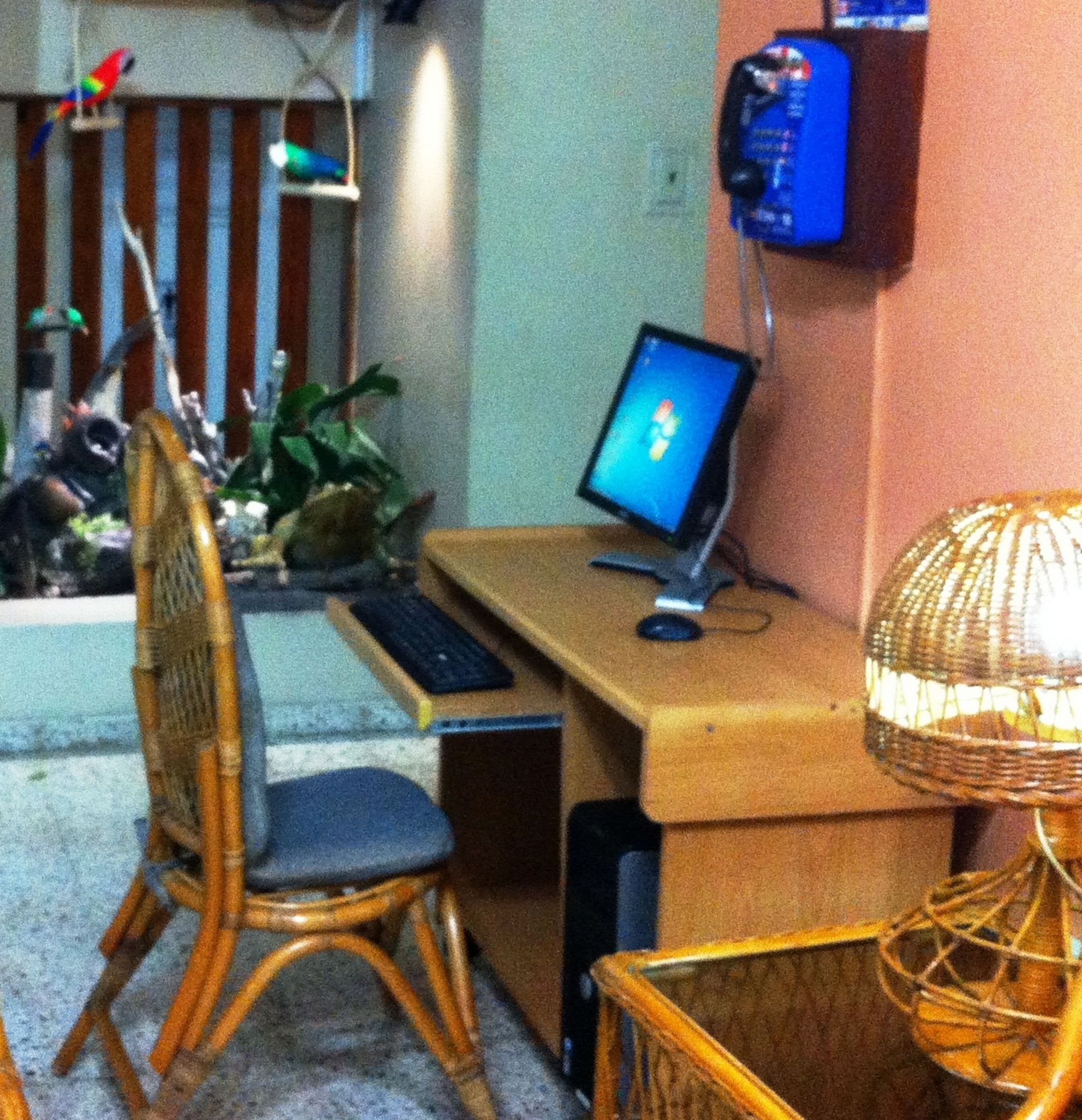 A room with a wooden desk, a computer, a chair, and a lamp.