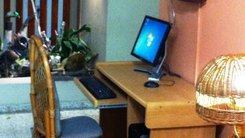 Una habitación con un escritorio de madera, una computadora, una silla y una lámpara.