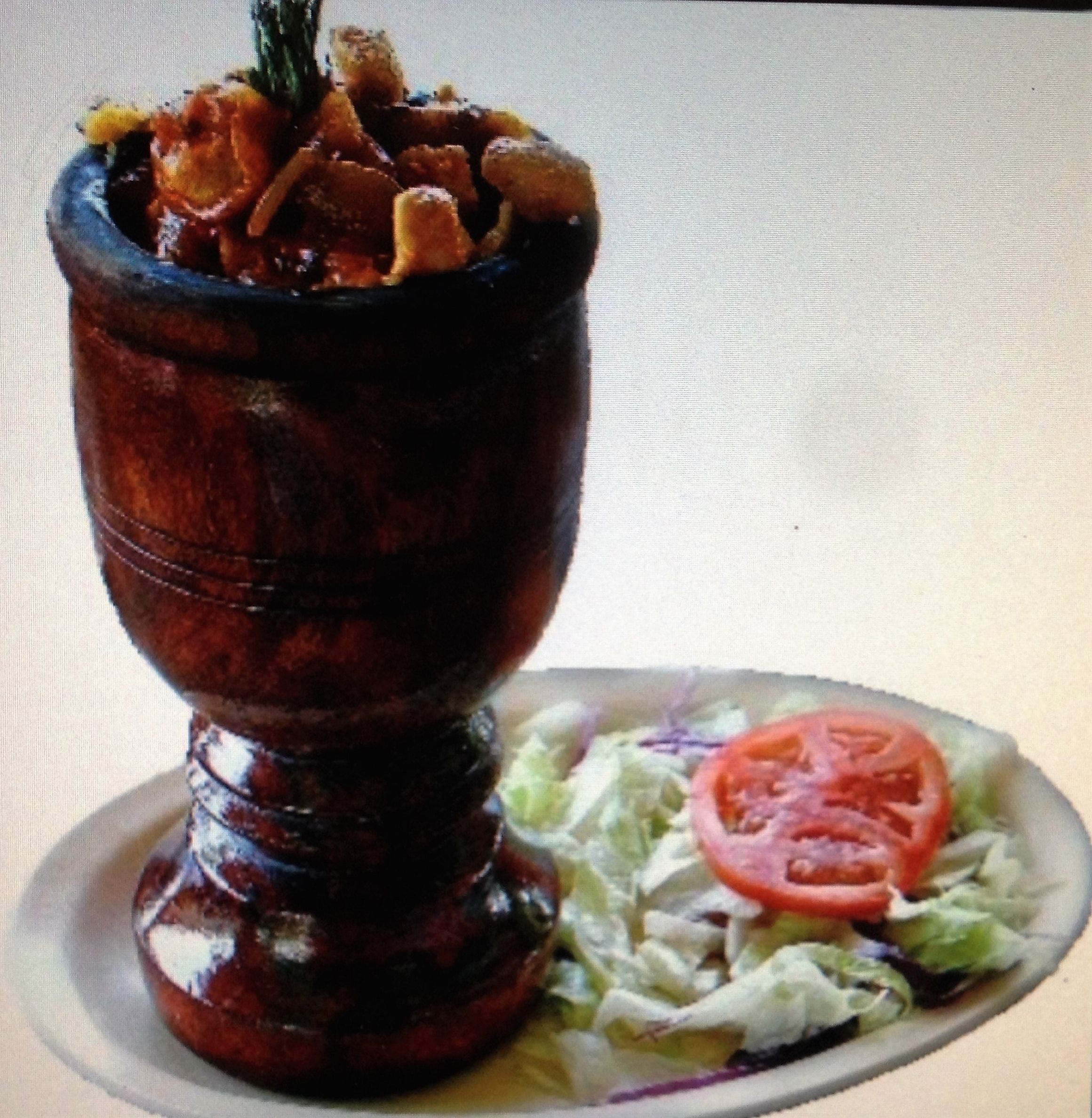 Un plato de comida con una ensalada al lado.