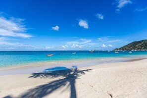 On the beach, white sand, sun-loungers, beach umbrellas