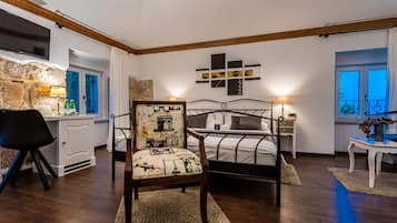 Un dormitorio con una cama, una silla, un escritorio, un televisor y una ventana.