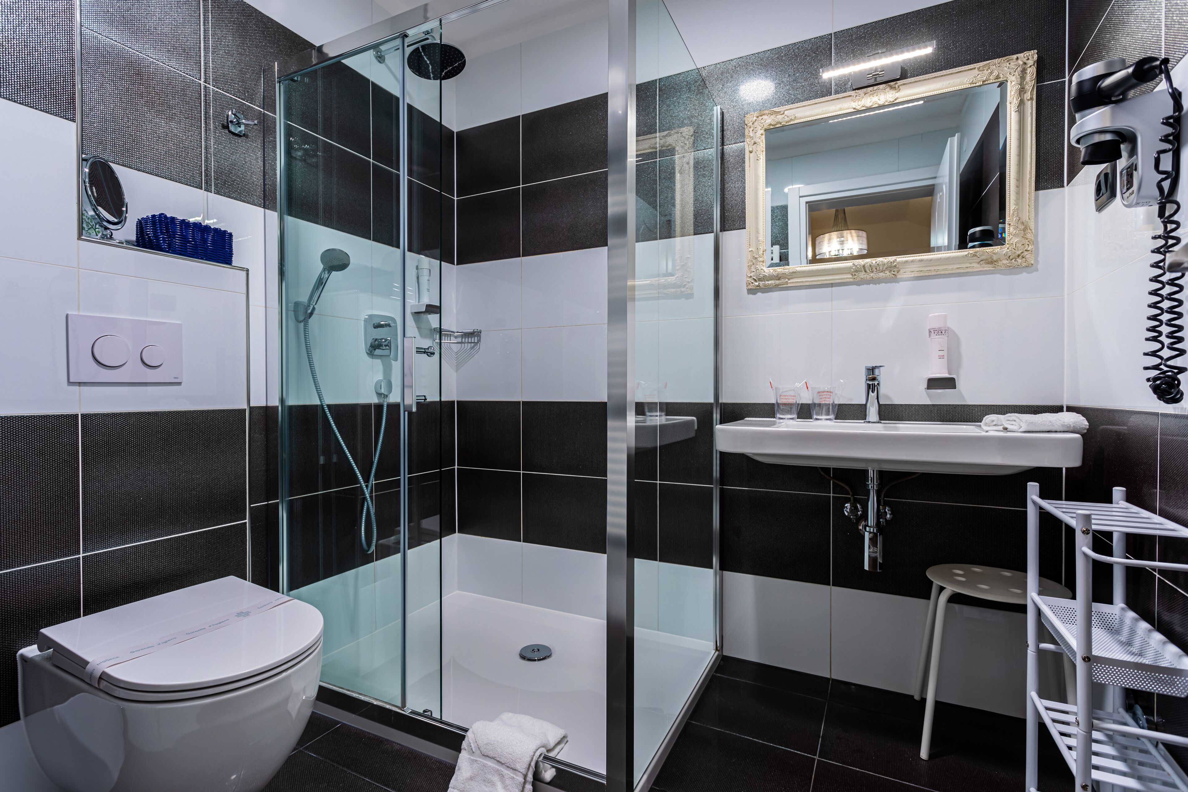 A modern bathroom with a glass-enclosed shower, a white sink, and a toilet.