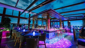 An indoor bar area with seating and a bar counter, large windows, and a view of the cityscape. - Assila, a Luxury Collection Hotel, Jeddah (Jeddah)