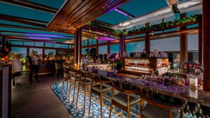A modern bar area with a long counter, bar stools, and a variety of bottles and glasses. - Assila, a Luxury Collection Hotel, Jeddah (Jeddah)