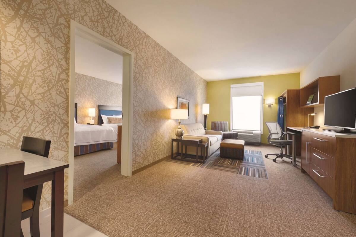 Une chambre d’hôtel équipée d’un lit, d’un bureau, d’une chaise et d’un téléviseur.