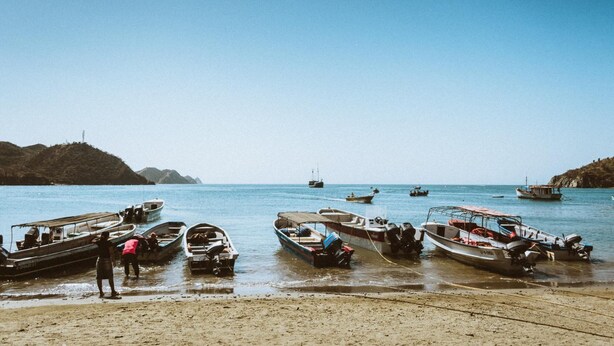 A beach with several boats docked near the shore. - Hostal Acuarius (Santa Marta)
