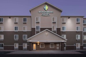 A multi-story hotel with a prominent 'Woodspring Suites' sign.