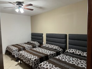 A bedroom with two beds, a ceiling fan, and a tiled floor. - Hotel Posada Ruisenor (San Juan de los Lagos)