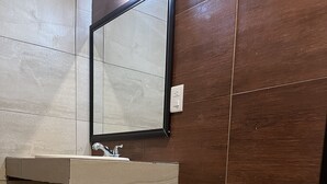 A bathroom with a toilet, a sink, and a mirror. - Hotel Posada Ruisenor (San Juan de los Lagos)