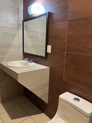A bathroom with a white sink, a mirror, and a toilet. - Hotel Posada Ruisenor (San Juan de los Lagos)