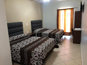 Una habitación de hotel con dos camas, un escritorio y un televisor.