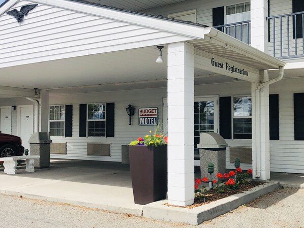A building with a covered entrance labeled "Guest Registration" and a sign for "Budget Motel." - Budget Motel (Burley)