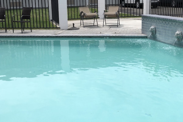 Una piscina al aire libre, tumbonas