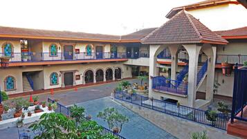 A courtyard with a central fountain, surrounded by buildings with balconies and arches.