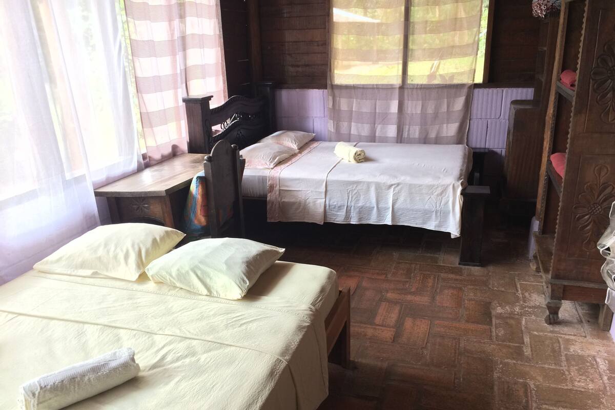 Habitación cuádruple, 2 camas dobles, baño compartido, vistas parciales al mar | Tabla de planchar con plancha y ropa de cama