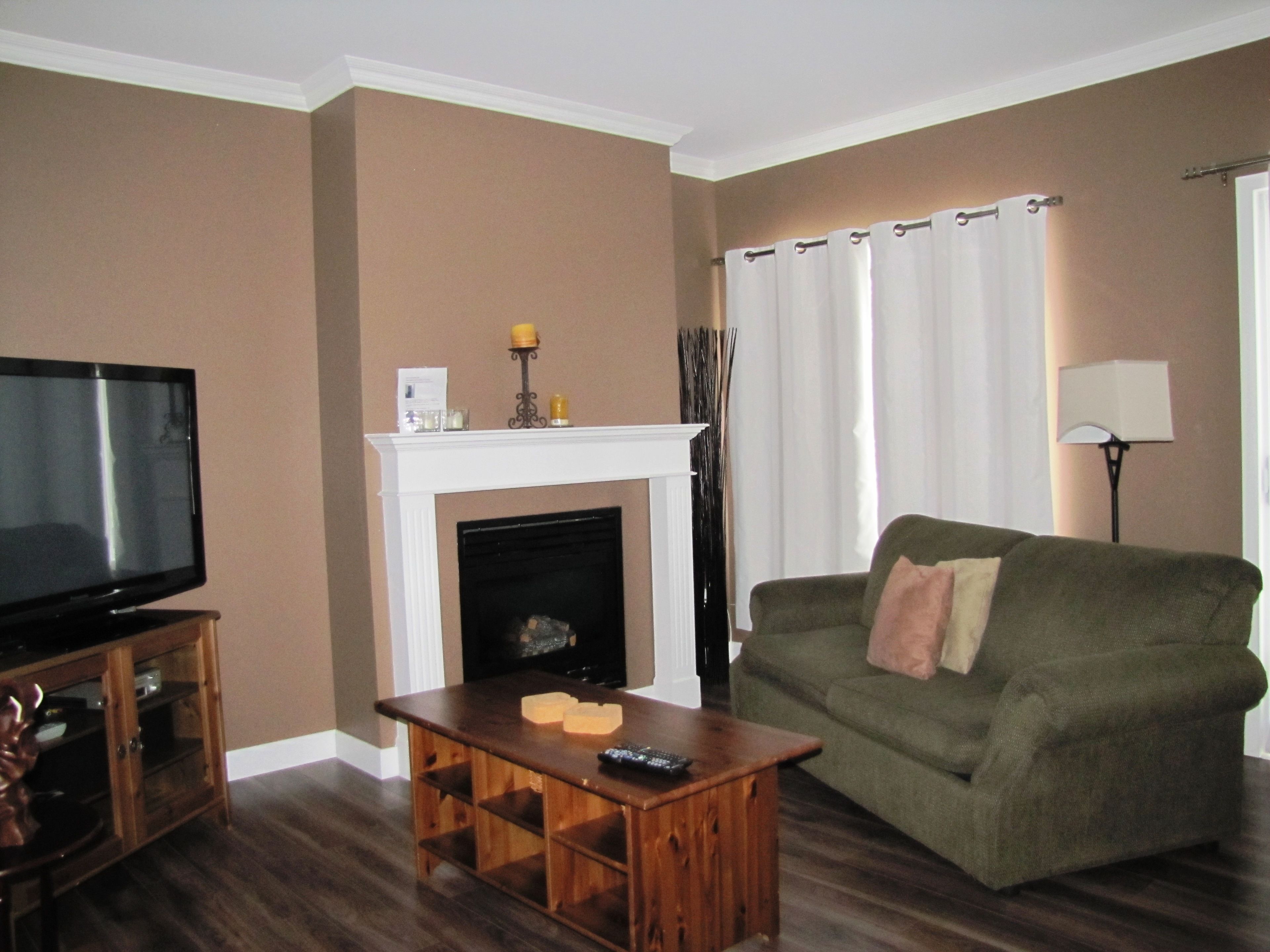 A living room with a fireplace, a television, a sofa, and a lamp.