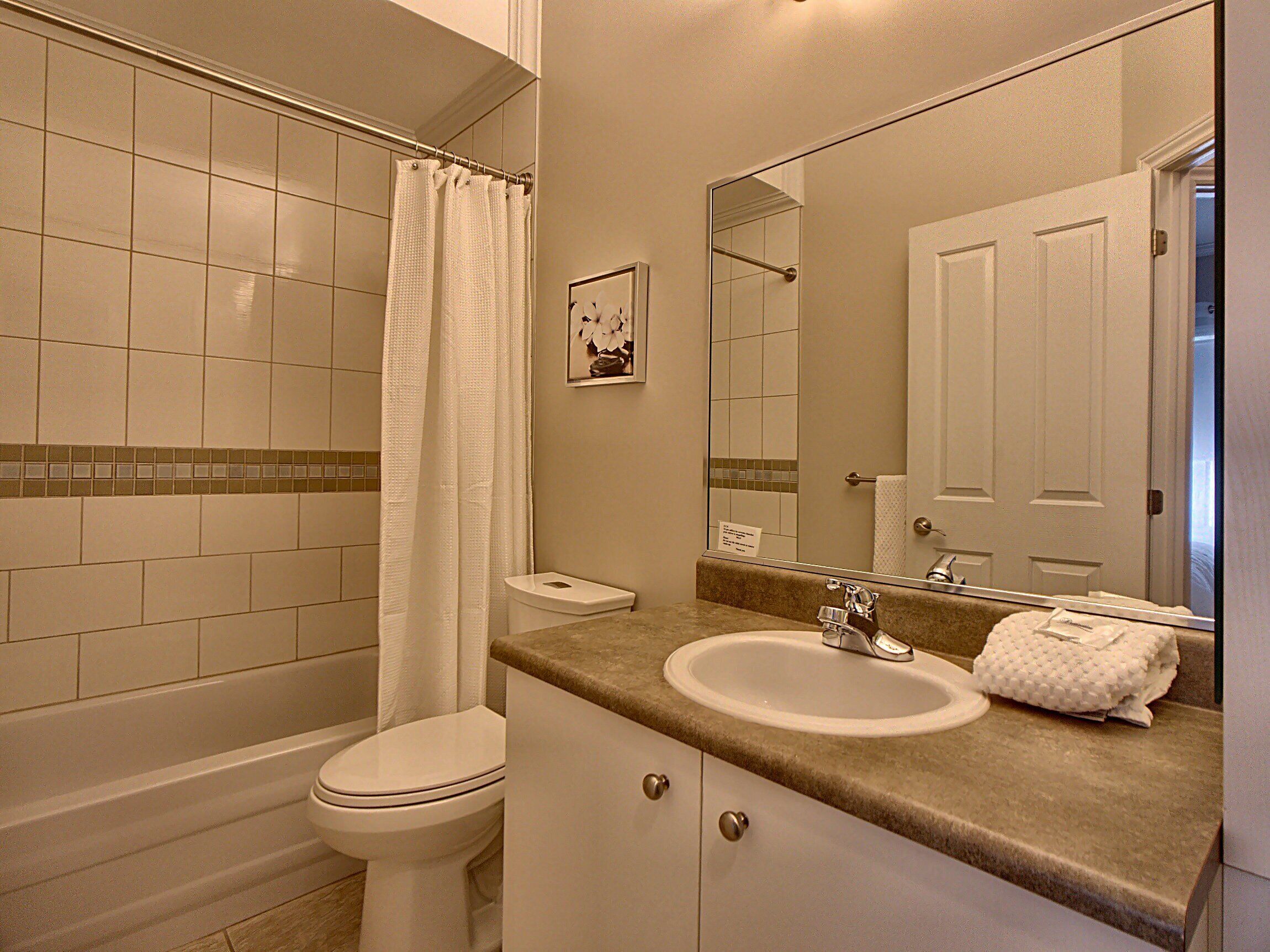 A bathroom with a toilet, sink, and shower.
